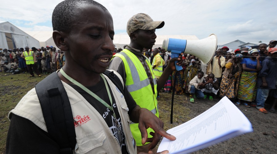Calling out beneficiary names during an aid distribution in Kibati camp, DRC