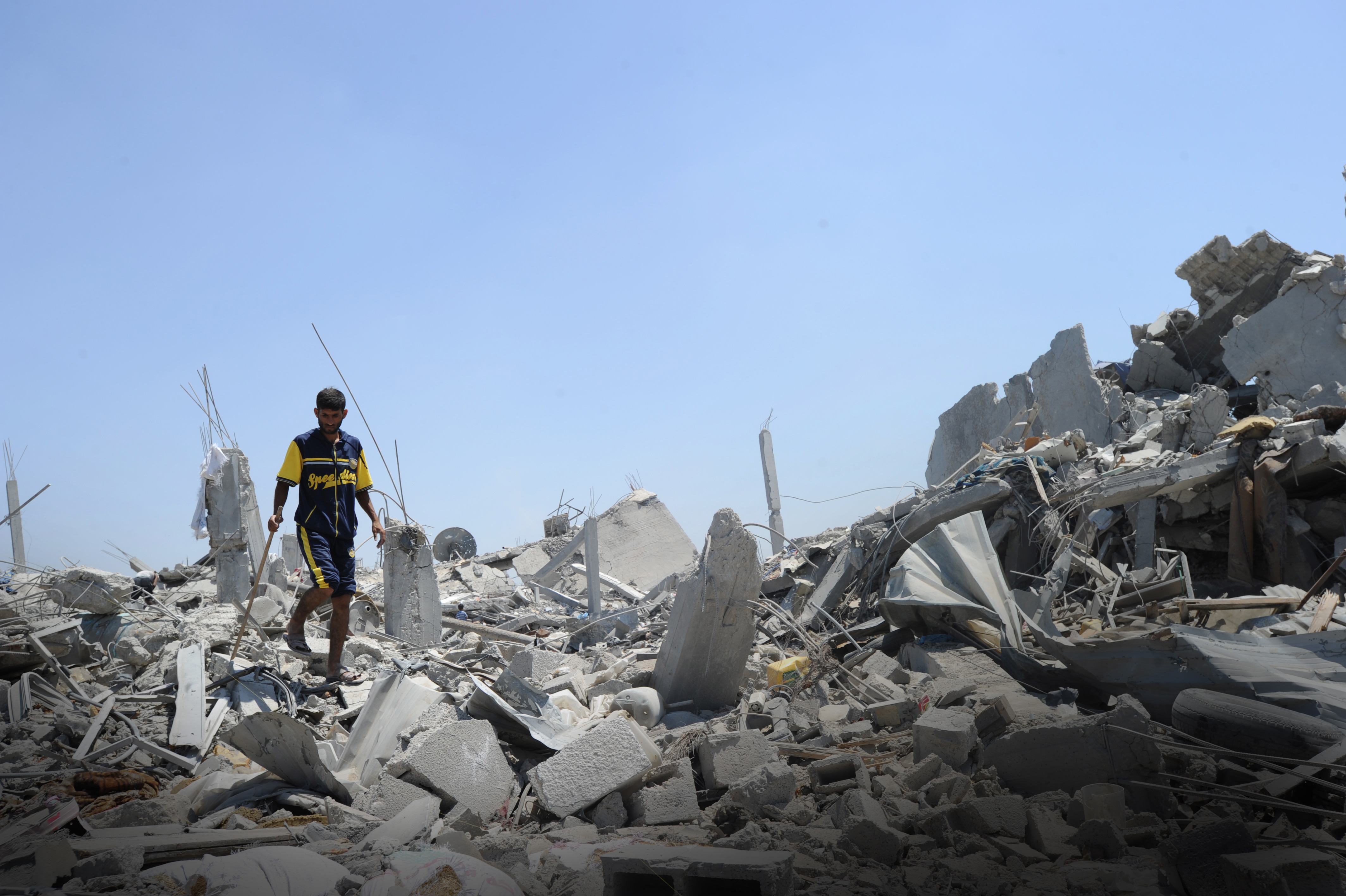 A Palestinian searches through the rubble of his home, Gaza