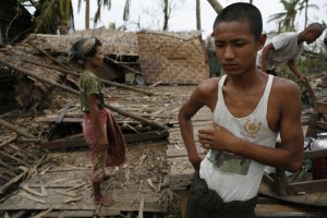 Residents walk among the debris of a home near Kunyangon