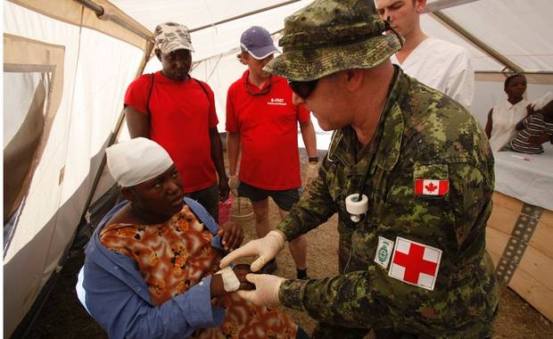 Canadian army medic Richard Robichaud treats a lady at a makeshift hospital of the Belgian First Aid and Support Team (B-FAST) in a suburb of the Haitian capital of Port-au-Prince January 18, 2010