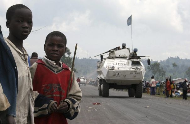 Children watch as U.N. peacekeepers in armoured personnel carriers (APC) patrol a key road linking Goma and Rutshuru in eastern Congo, October 28, 2008