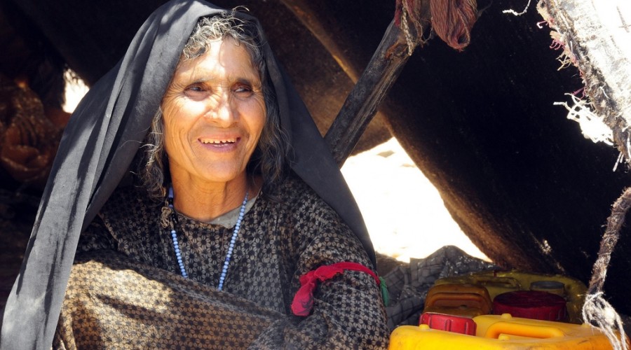 An elderly Afghan woman in tent as her tribe receives humanitarian assistance