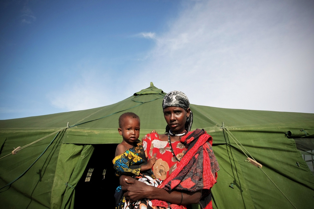 A Somali woman and a malnourished child exit from the medical tent after the child receives emergency medical treatment from the African Union Mission in Somalia (AMISOM)