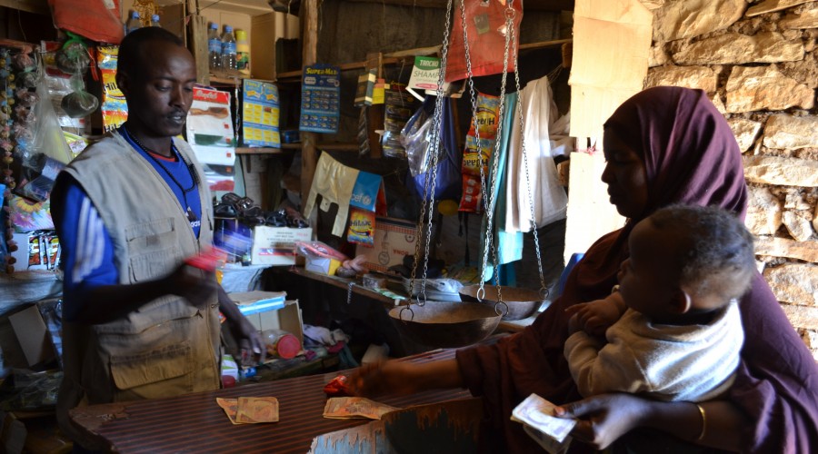 A woman shops using money provided by Adesos cash transfer programme in Somalia