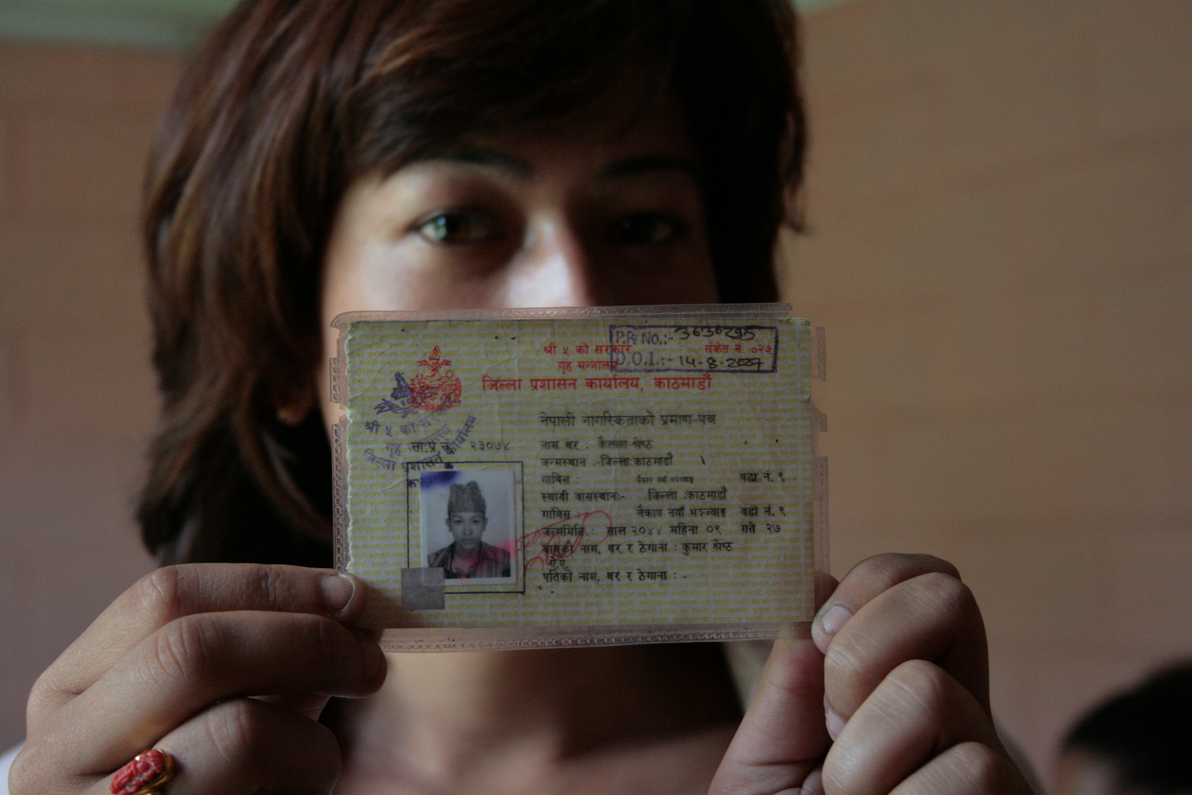 A Nepali transgender activist holds up her citizenship certificate