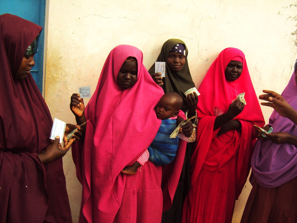 Women in Hiran, Central Somalia displaying beneficiary identification cards after receiving cash grants