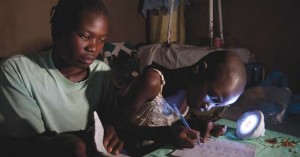 A girl studies at night using a solar-powered light bought from an entrepreneur trained by Christian Aid partner ADS, Kenya