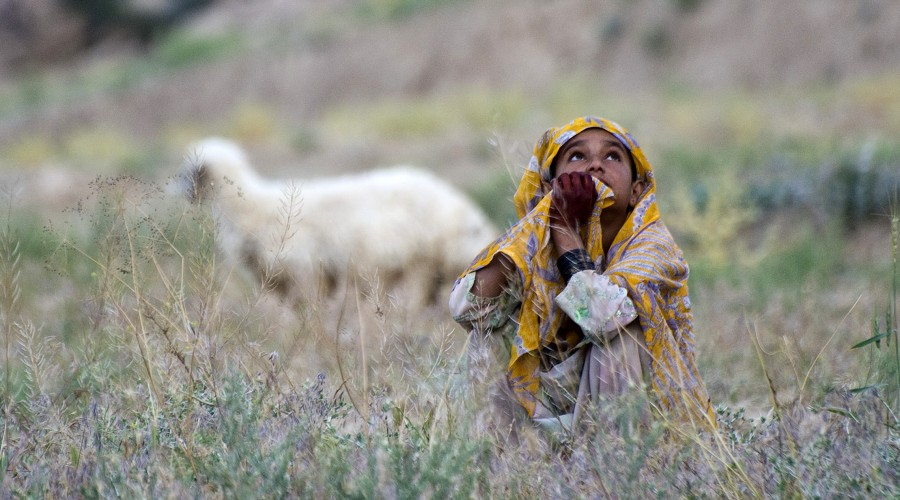 An Afghan girl watches a coalition aircraft during a “village clearing operation” in northern Khakrez District, Kandahar province, Afghanistan.