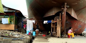 A girl from Tacloban takes on household chores under makeshift housing