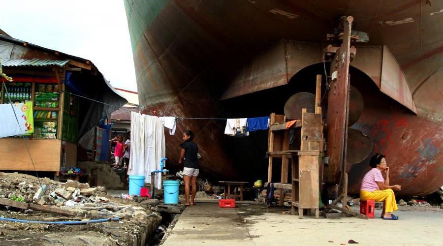 A girl from Tacloban takes on household chores under makeshift housing