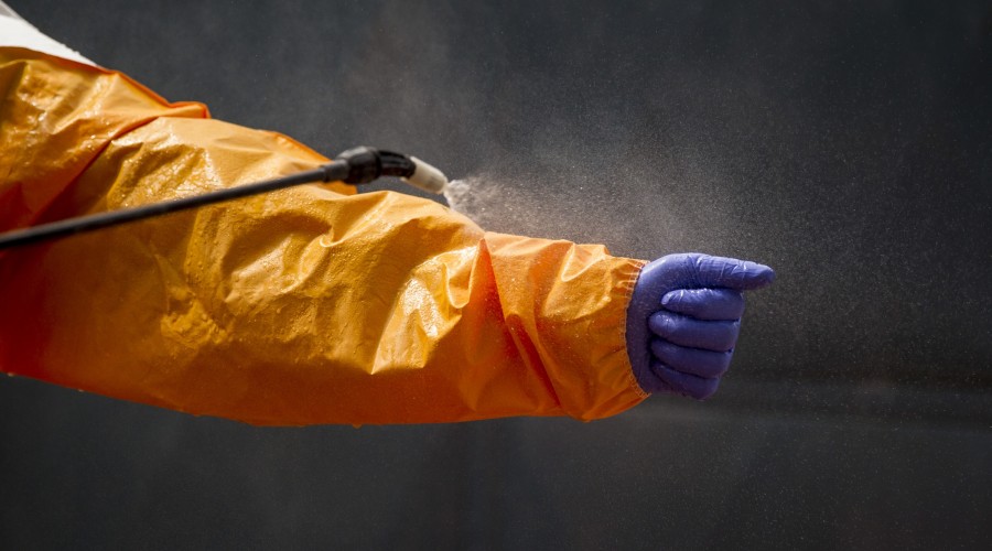 Burial team volunteers disinfect themselves in Conakry, Guinea