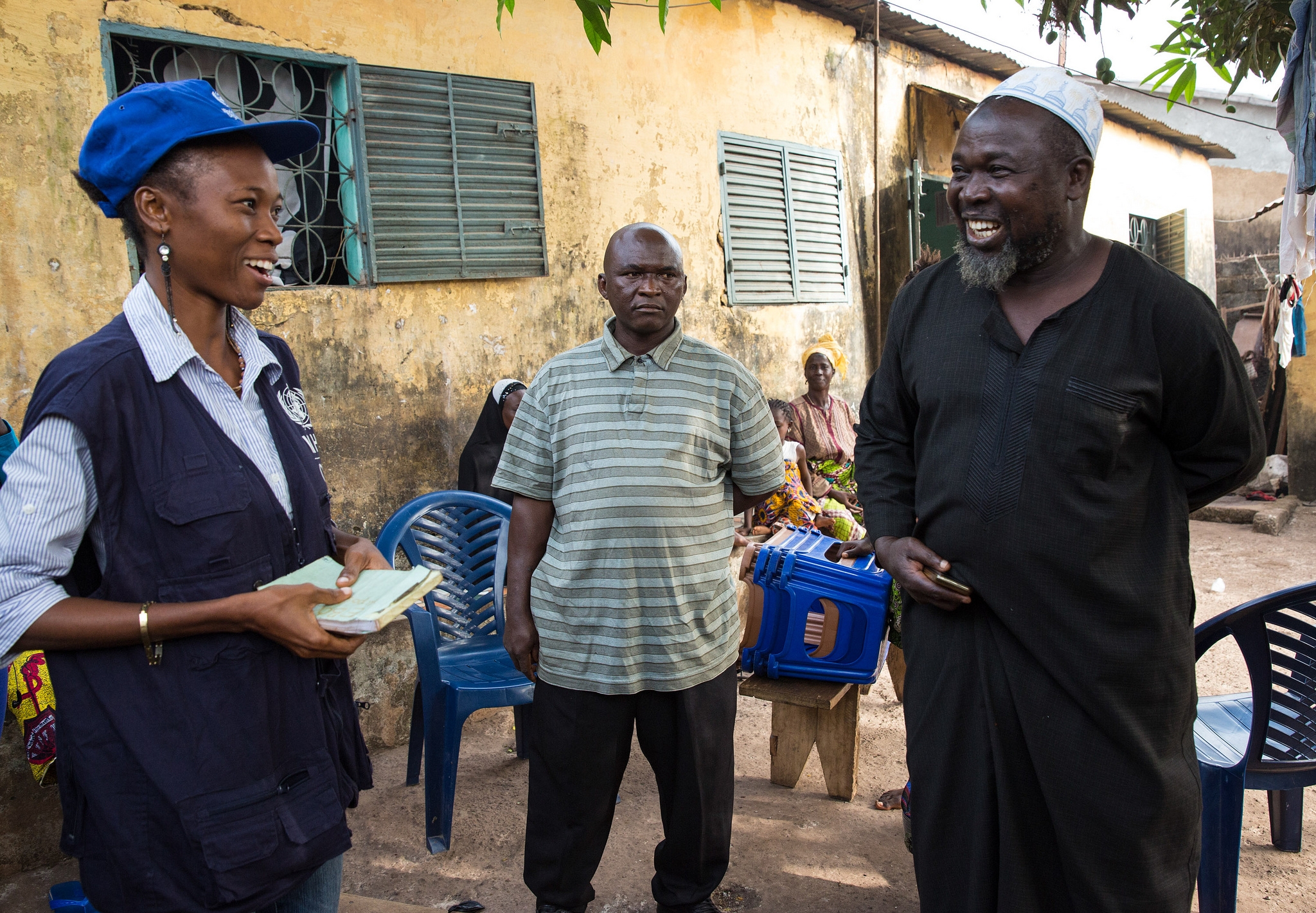 A member of a WHO contact tracing team talks to the head of a family in Conakry, Guinea