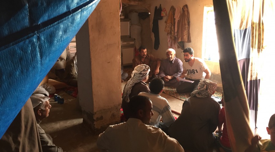 A data collector facilitates a focus group discussion with IDP men using the CLARA tool in Iraq