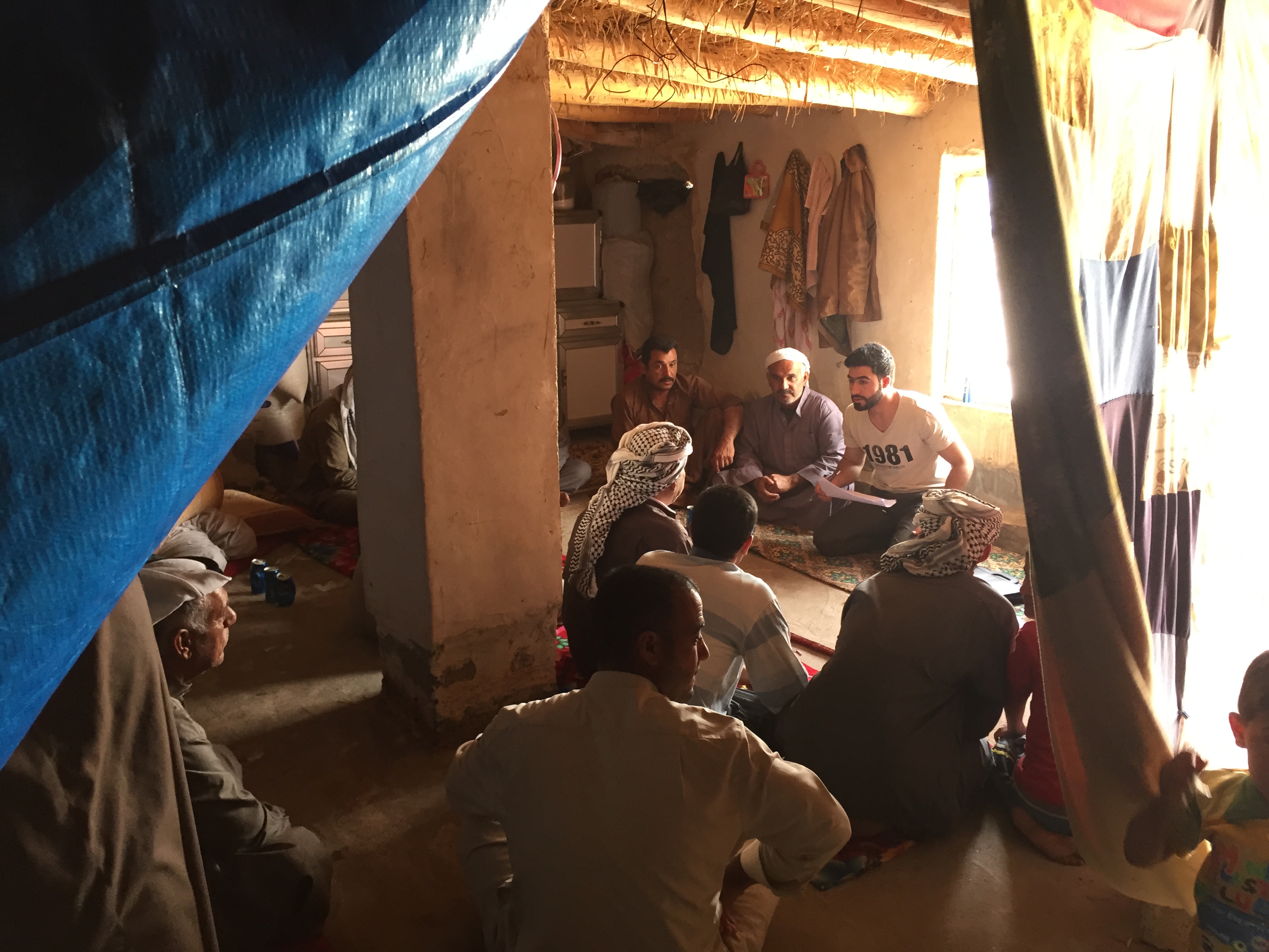 A data collector facilitates a focus group discussion with IDP men using the CLARA tool in Iraq