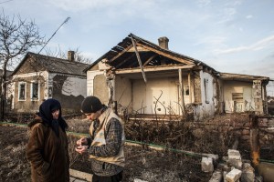 A member of a shelter team speaks with a woman in the village of Hranitne, eastern Ukraine