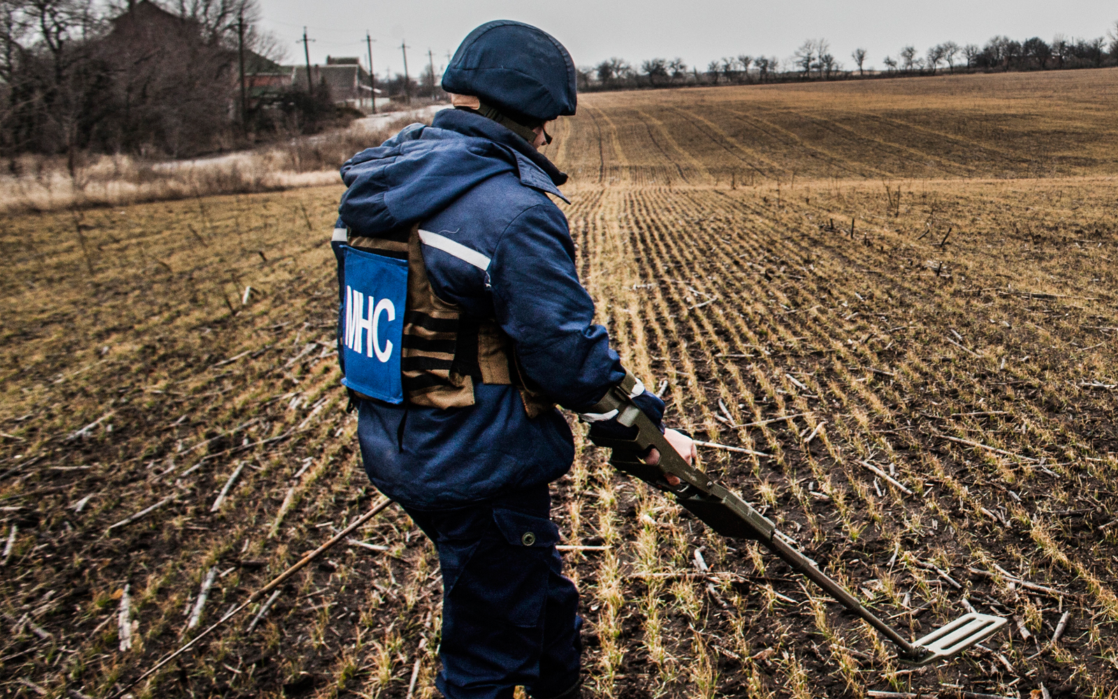 A member of a demining and unexploded ordinance clearance team in a field on the outskirts of Mariupol, eastern Ukraine