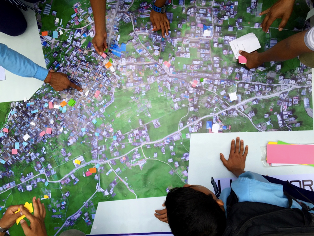 Residents of Panga, Nepal use aerial imagery to take part in a disaster damage assessment