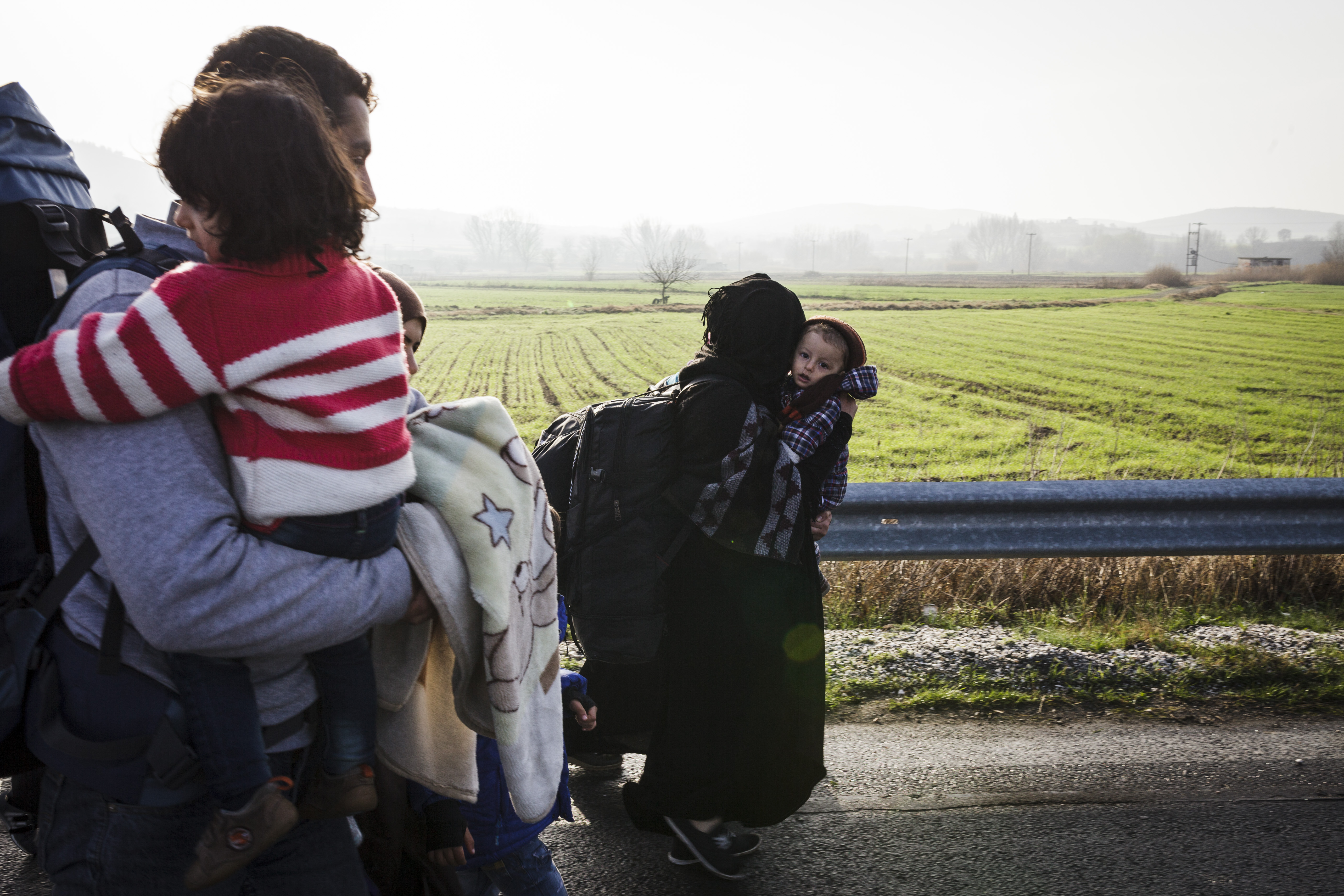 A family of Kurdish refugees from Aleppo walk towards the village of Idomeni on the Greek - FYR of Macedonia border.