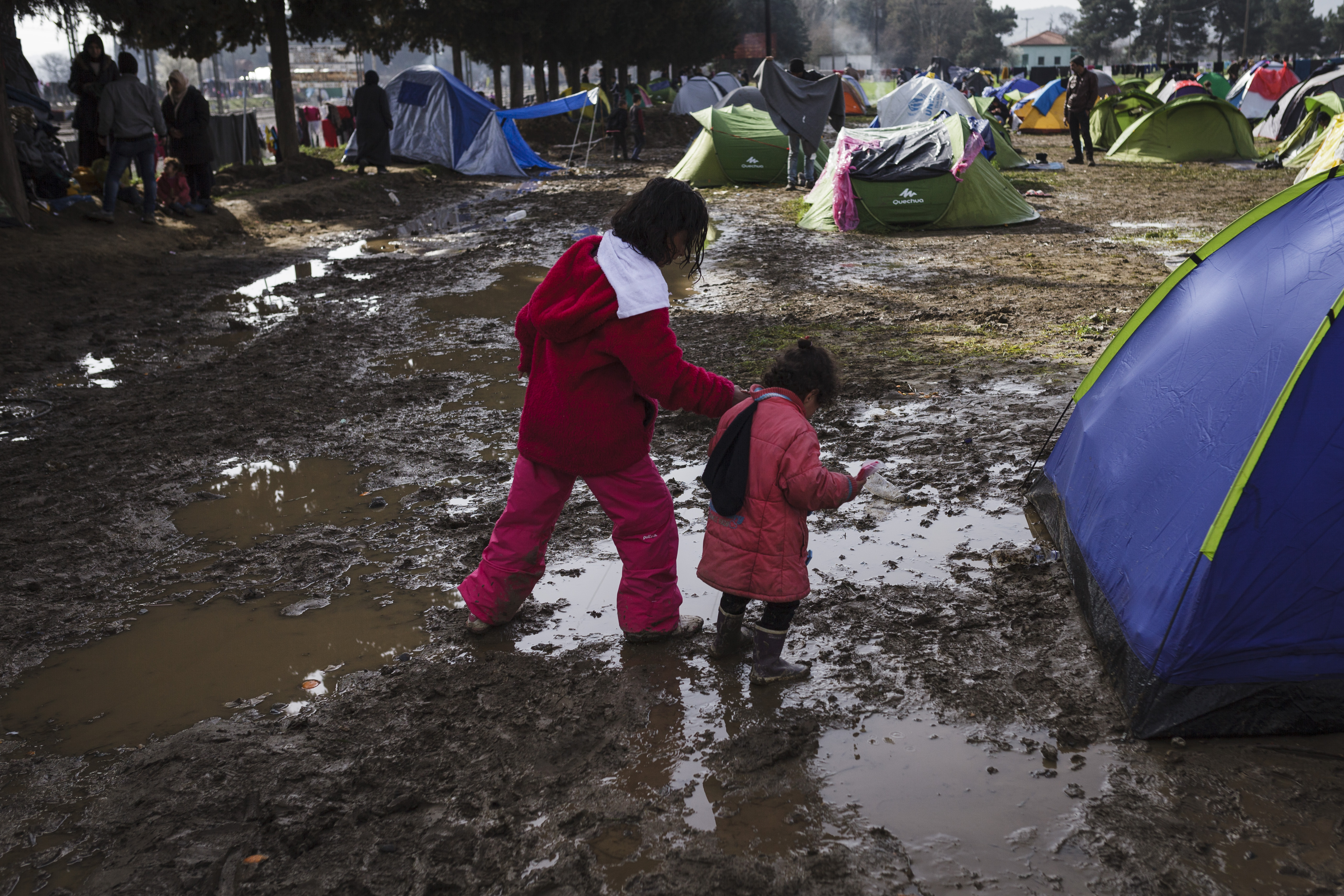 Two young girls walk through a makeshift camp near the village of Idomeni in Greece.