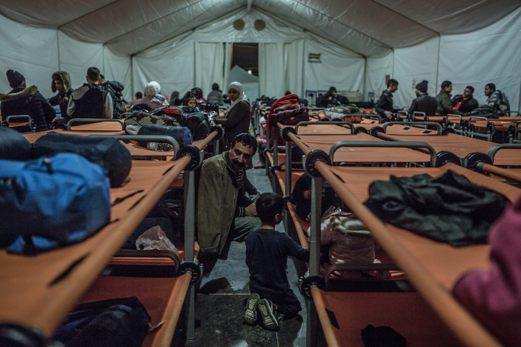 A refugee from Iraq rests with his family in an Oxfam shelter after ...