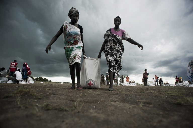 Women collecting sorghum and oil some hours after an airdrop conducted by the ICRC in Unity State, South Sudan.
