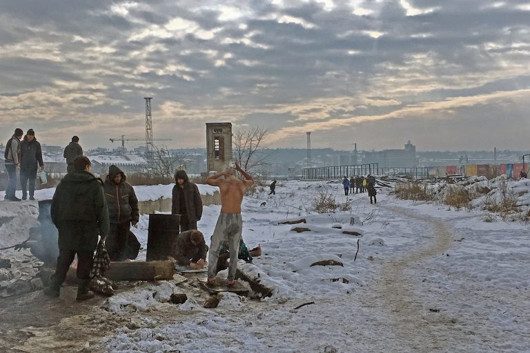 A man showers in the snow as authorities have not allowed toilets and showers to be brought to the warehouse. Belgrade, Serbia