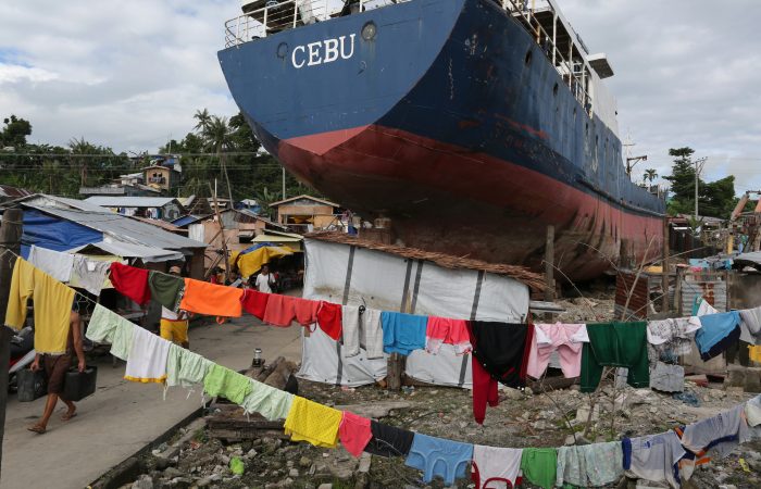 Residents affected by typhoon Haiyan (Yolanda) carry on with their daily activities on July 13, 2014, eight months after the super typhoon destroyed lives, livelihoods and property and swept ships on the shores of Tacloban city.