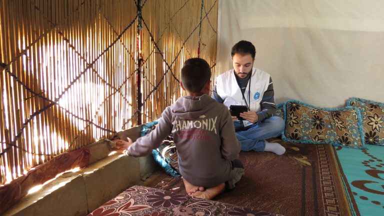 An interview being conducted with a Syrian boy in an informal tented settlement in Beqaa, Lebanon.