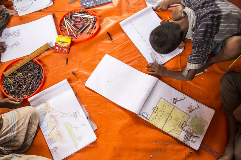 Rohingya children in a UNICEF child-friendly space at Batukhali refugee camp in Bangladesh draw pictures of what they witnessed in Burma.