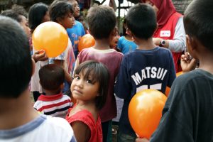 Children are entertained outside a PMI mobile medical clinic in a remote village in Donggala, Central Sulawesi, Indonesia.