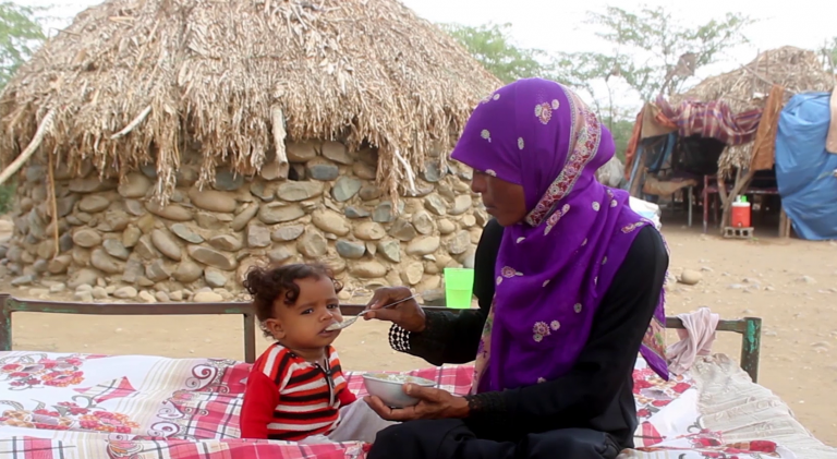 A mother feeding her daughter in the malnutrition hit Aldhahi district after a nutrition awareness session.