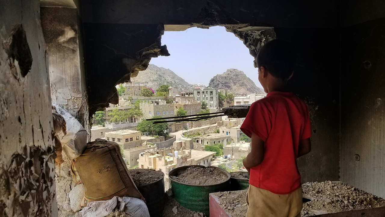 Child inspects their destroyed house due to the war in Yemen.