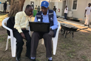 Deux préposés à la surveillance discutant des ICP au centre des opérations d’urgence à Beni, au Nord-Kivu.