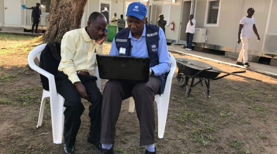 Deux préposés à la surveillance discutant des ICP au centre des opérations d’urgence à Beni, au Nord-Kivu.