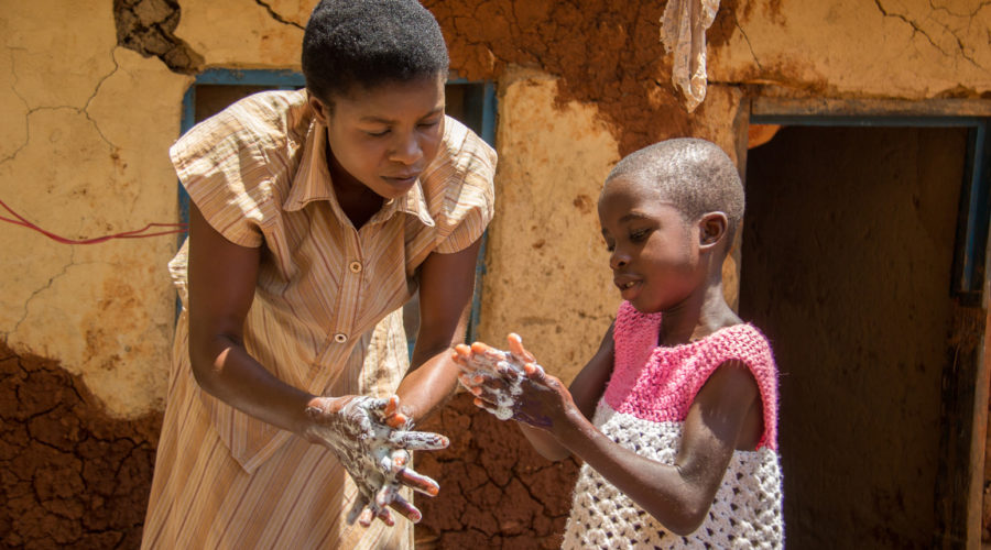 Octobre 2018, Nord-Kivu, République démocratique du Congo. Martine Kavucho, 30 ans, montre à sa fille Christine Botulu, 6 ans, les techniques de lavage des mains qu’elle a apprises au centre de santé dans le cadre de la réponse de Mercy Corps à Ebola