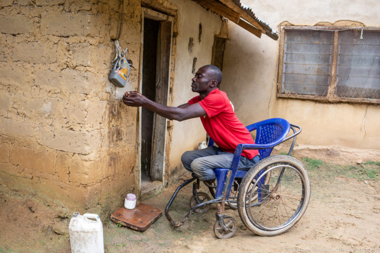 David Undie, a person with disabilities, using an accessible hygiene facility in Nigeria